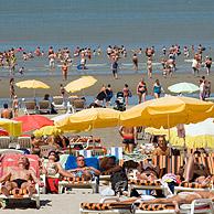 Toeristen zonnebadend op strand tijdens de zomer aan de Noordzee, Blankenberge, België
